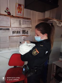 Una agente de Policía con el bebé encontrado en un supermercado de Ávila en brazos.