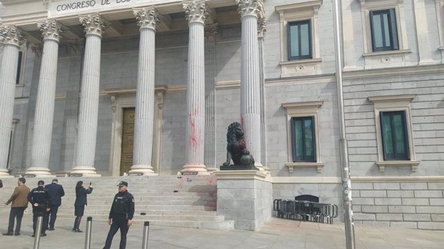Dos agentes de Policía Nacional delante de las escalinatas del Congreso de los Diputados que han sido teñidas con pintura roja por activistas de Futuro Vegetal y Rebelión Científica, a 30 de marzo de 2023, en Madrid (España). 