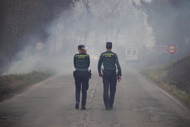 Dos agentes de la Guardia Civil regulan el tráfico en el incendio de los concejos de Valdes y Tineo