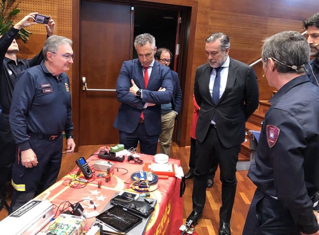 Enrique López (en el centro a la derecha) y Carlos Novillo (en el centro a la izquierda) reciben consejos de los Bomberos sobre uso correcto de baterías en la sede de ASEM 112.