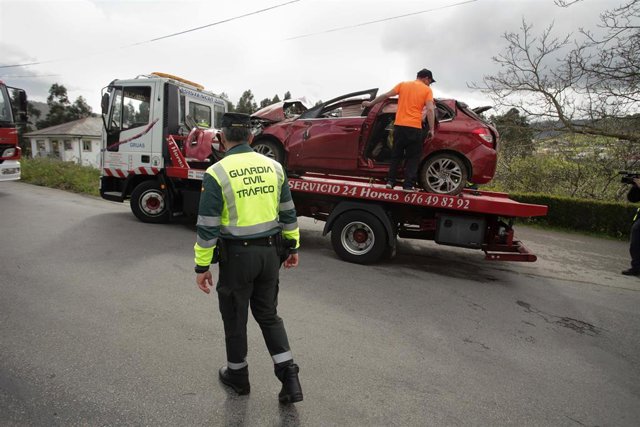 Un Guardia Civil vigila la retirada del coche siniestrado, en el accidente, por una grúa, a 1 de abril de 2023, en Xove, Lugo, Galicia, (España). Dos hombres y dos mujeres, vecinos de Ribadeo, han fallecido en un accidente de circulación registrado en la 