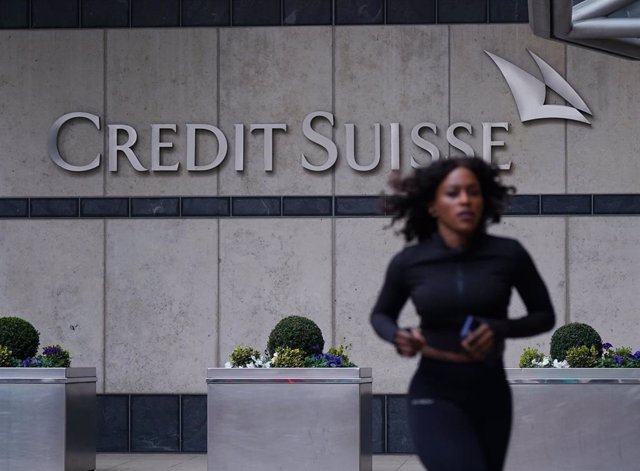 19 March 2023, United Kingdom, London: A woman runs in front of the Credit Suisse UK offices in Canary Wharf. Swiss banking giant UBS is acquiring its ailing smaller rival Credit Suisse in an emergency rescue deal, with the historic mega-merger getting th