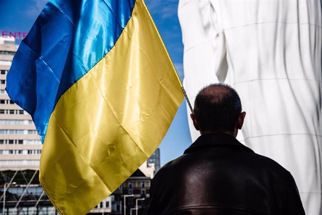 Archivo - Un hombre porta una bandera de Ucrania durante una concentración para pedir el fin de la guerra en Ucrania.