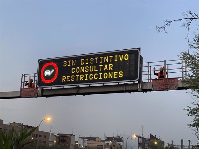 Dos activistas de Futuro Vegetal junto al cartel luminoso de la M-30.