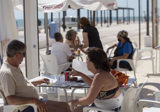 Archivo - Imagen de archivo de dos personas en un bar del paseo marítimo de la playa de Matalascañas.