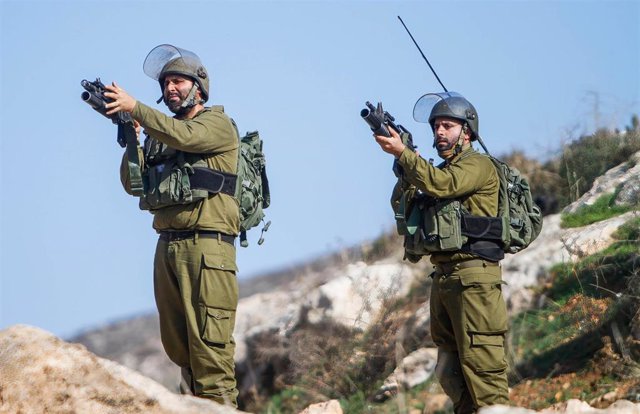 Archivo - Soldados israelíes apuntan con sus armas a los manifestantes palestinos durante una manifestación contra los asentamientos israelíes en el pueblo de Beit Dajan, cerca de la ciudad cisjordana de Nablús