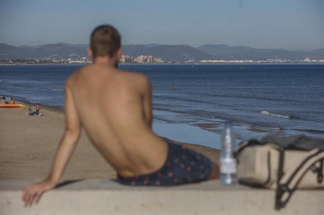 Archivo - Un chico en bañador toma el sol en la playa