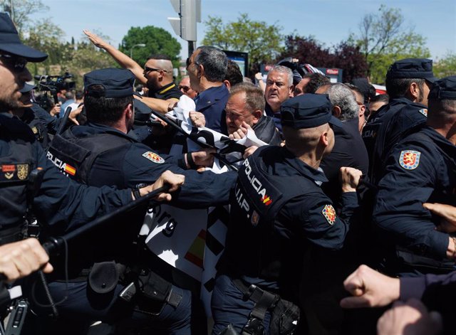 Varios agentes de Policía Nacional frente a varios simpatizantes de la Falange, antes de la llegada del coche fúnebre con los restos de José Antonio Primo de Rivera, en el cementerio sacramental de San Isidro, a 24 de abril de 2023, en Madrid (España).