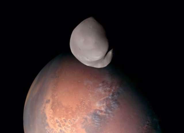 Imagen de Deimos con Marte al fondo tomada por la nave Hope