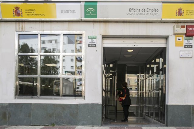 Archivo - Una mujer entra en una oficina de Empleo en Sevilla, en una imagen de archivo.