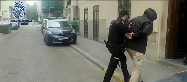 Un agente custodia a uno de los detenidos.