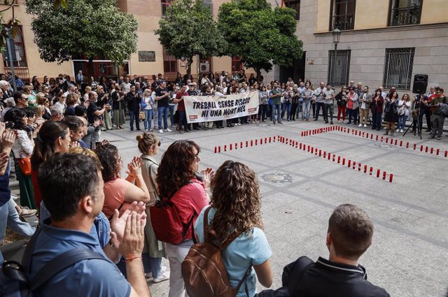 Varias personas participan en un acto simbólico organizado por CCOO PV por el Día Mundial de la Seguridad y la Salud en el Trabajo, en la Plaza de Nápoles y Sicilia de València