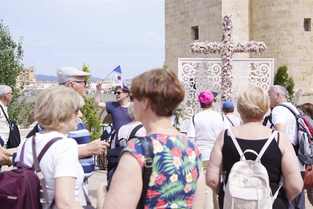 Turistas junto a la Cruz de Mayo situada junto a la Torre de la Calahorra y el Puente Romano de Córdoba.