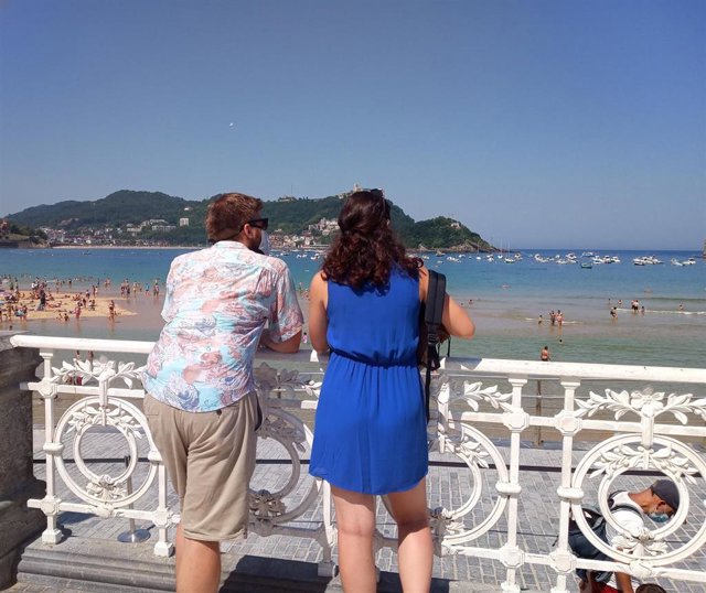 Archivo - Una pareja contempla las vistas de la Playa de la Concha en San Sebastián el día en el que las temperaturas máximas podrían alcanzar los 37 grados en la zona costera del País Vasco, en San Sebastián, Guipúzcoa, Euskadi (España) a 30 de julio de 