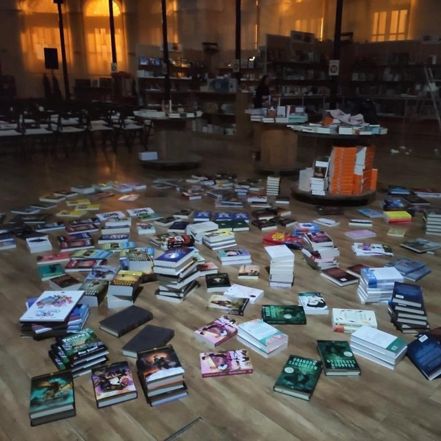 Libros de LibrOviedo en el suelo en la Plaza de Trascorrales.