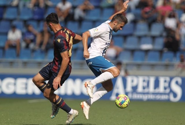 Dos jugadores del Tenerife y del Levante pelean por un balón.