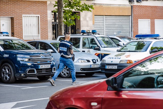 Dos vehículos y un agente de Policía Nacional en el domicilio donde han apuñalado a una mujer, en la calle Centro de Móstoles, a 8 de mayo de 2023, en Móstoles, Madrid (España).