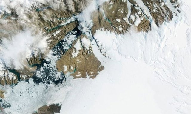 En el centro de esta fotografía de la NASA tomada en 2012, el glaciar Petermann en el noroeste de Groenlandia se mueve gradualmente hacia el océano, con grandes segmentos que se desprenden y se alejan como icebergs.