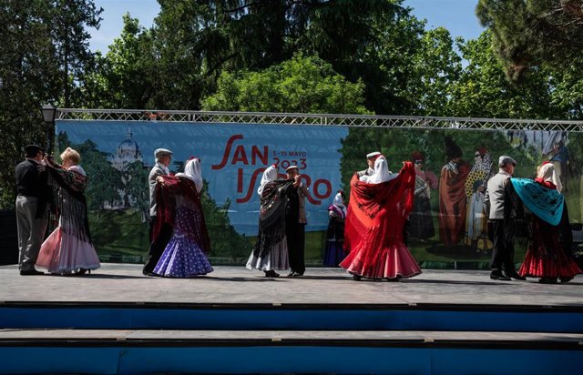 Varias personas vestidas de chulapos bailan chotis durante la presentación de la programación de las Fiestas de San Isidro 2023