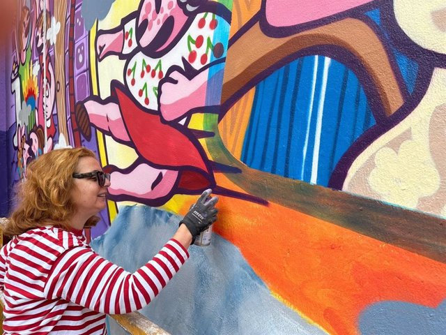 La artista pintando el mural