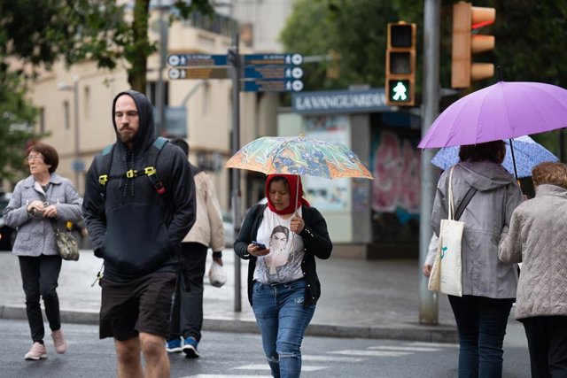 Varias personas con paraguas pasean por una de las calles de la ciudad, a 12 de mayo de 2023, en Barcelona, Catalunya (España). Casi todas las comarcas de Catalunya estarán pendientes hoy de una nueva tanda de chubascos y tormentas como consecuencia de la