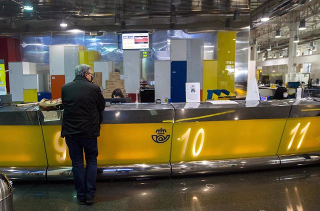 Archivo - Un cliente es atendiendo en la Oficina de Correos de Cibeles, en Madrid, (España), a 16 de marzo de 2021. 