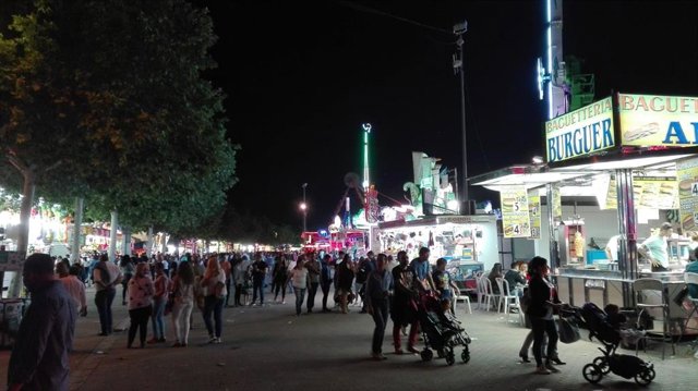 Archivo - Familias pasean junto a atracciones en la Feria de Córdoba.