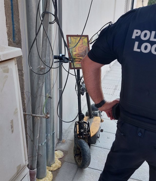 Un agente de la Policía Local de Adra junto al patinete con una fotode Franco empleado para el atropello