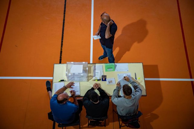Un home espera al fet que els components de la taula electoral compueben la seva identitat per votar en l'Escola Grèvol, a 28 de maig de 2023, a Barcelona, Catalunya (Espanya). Avui, 28M, se celebren eleccions municipals en un total de 8.131 ajuntaments i