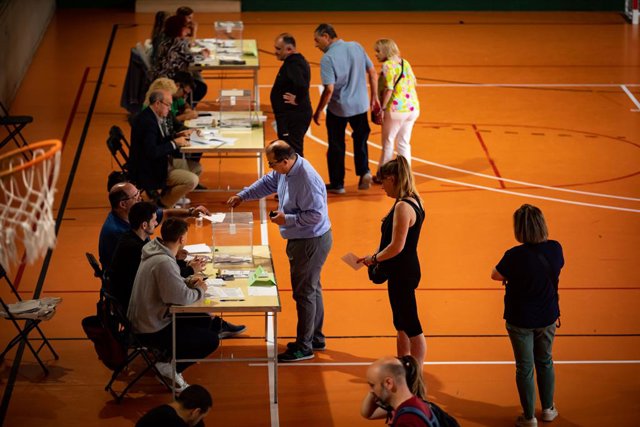 Diverses persones fan cua per votar 
