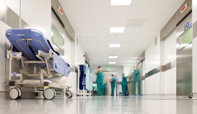 Archivo - Hospital surgery corridor  Blurred figures of people with medical uniforms in hospital corridor.