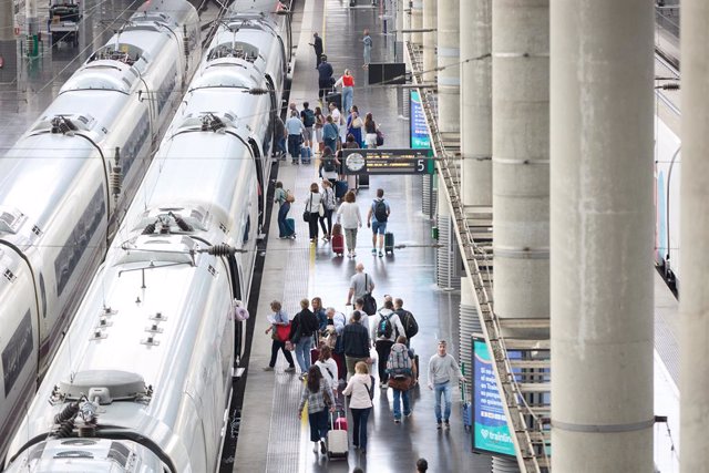 Archivo - Viajeros con maletas en uno de los andenes de la estación Almudena Grandes-Atocha Cercanías en Madrid (España).