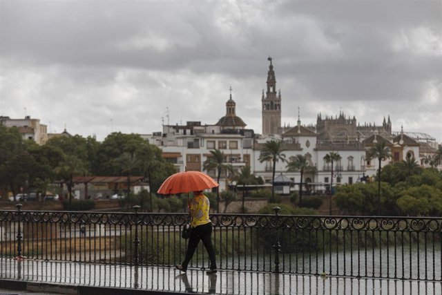 Archivo - Cielo nublado y lluvia desde el puente de Triana. Imagen de archivo.  
