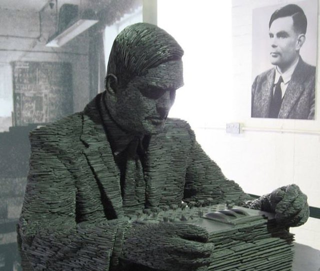 Estatua de Turing y su retrato de fondo.