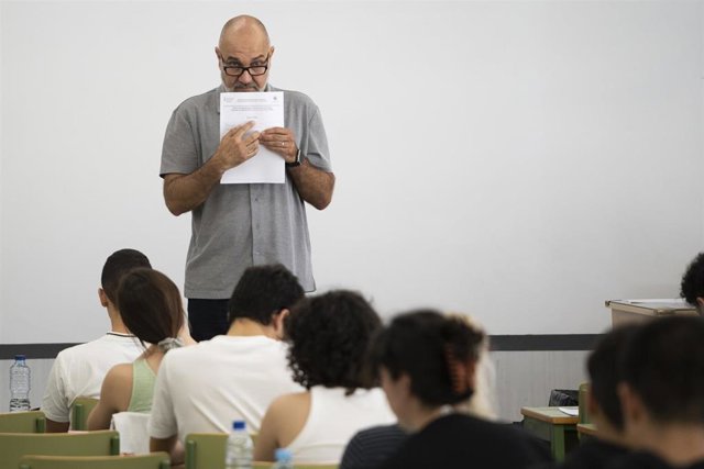 Un profesor sujeta una pila de exámenes antes de comenzar las pruebas de acceso a la universidad 2023 (archivo)
