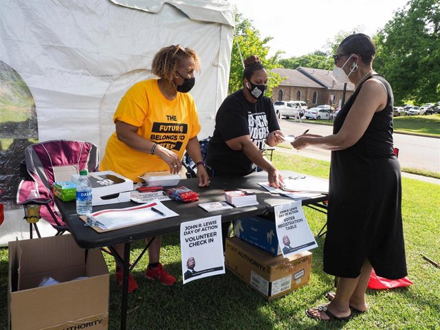 Archivo - Activistas que apoyan el derecho al voto repartiendo flyers en Montgomery, Alabama