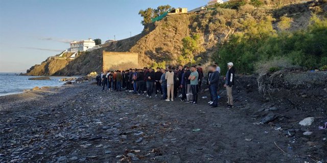 Inmigrantes que han alcanzado la playa de Adra (Almería) tras ser obligados a lanzarse al mar desde sus pateras.