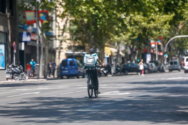 Archivo - Un 'rider' de la compañía de comida a domicilio, Deliveroo, circula con su bicicleta por una calle de Madrid.