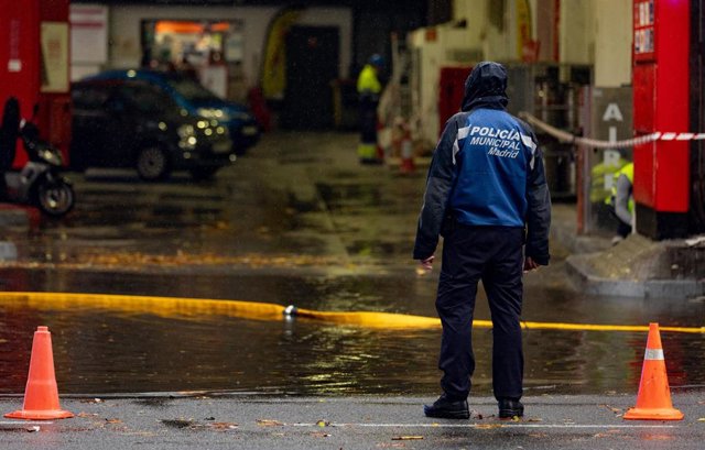 Archivo - Un agente de Policía en una balsa de agua de una gasolinera, en la Avenida de la Ciudad de Barcelona, a 14 de diciembre de 2022, en Madrid (España). 