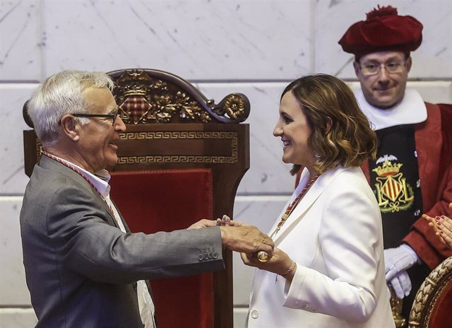 El alcalde saliente de Valencia, Joan Ribó (Compromís), entrega el bastón de mando a la alcaldesa entrante de la ciudad, María José Catalá (PP), en la sesión de constitución del Ayuntamiento de Valencia