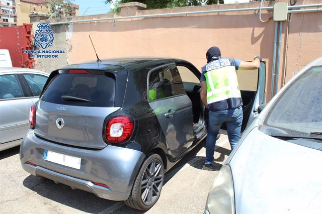 Un agente inspecciona uno de los vehículos caleteados usado por la red de narcotráfico para distribuir las drogas.