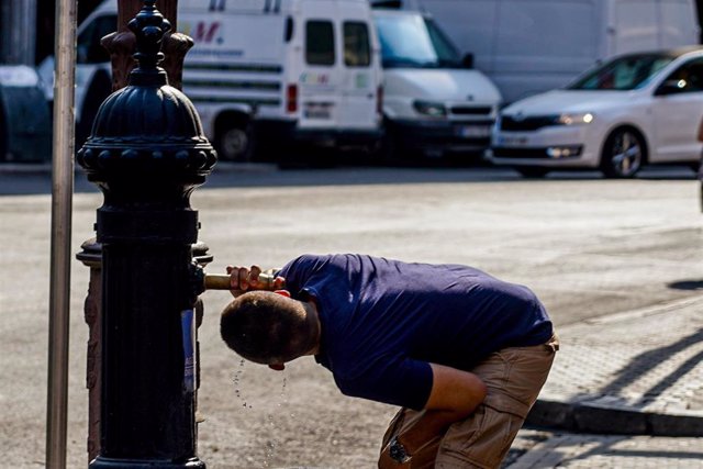 Archivo - Un joven bebe en una fuente en el centro de la ciudad por las altas temperaturas. Imagen de archivo.