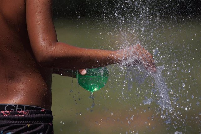 Un chico se refresca en Madrid Rio, a 26 de junio de 2023, en Madrid (España).