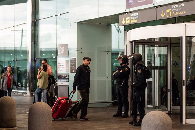 Archivo - Dos agentes de la Policía Nacional fente a una de las puertas de acceso al Aeropuerto de Barcelona-El Prat