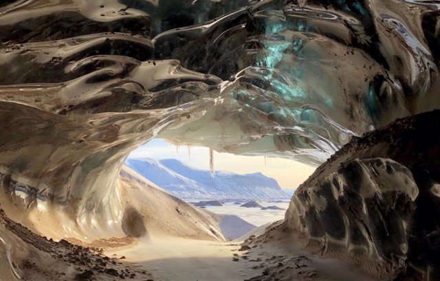 Cueva glaciar en Svalbard, Noruega, formada por grandes volúmenes de agua de deshielo glacial que fluye a través de ella durante el verano.