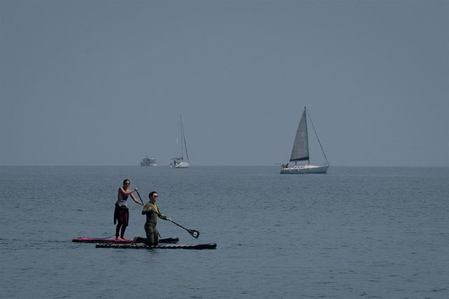 Archivo - Dos personas hacen paddle surf