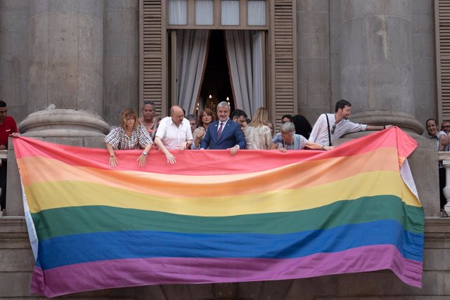 L'alcalde de Barcelona, Jaume Collboni (4d), ajuda a penjar la bandera LGTBIQ+  durant el Dia Internacional de l'Orgull a l'Ajuntament de Barcelona, a 28 de juny del 2023, a Barcelona
