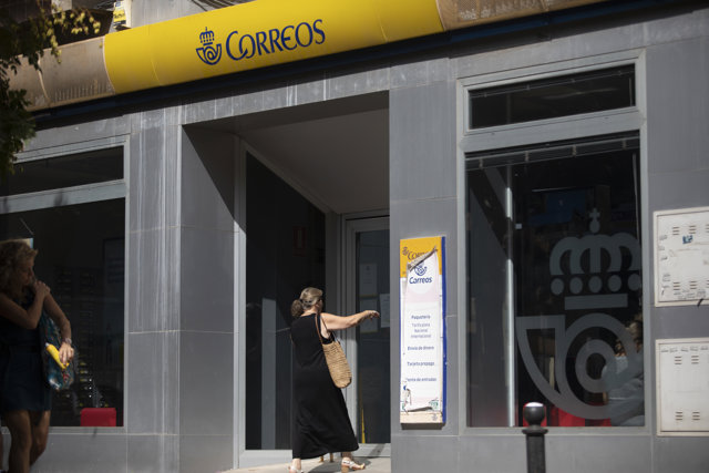 Una persona entra en una oficina de correos. A 17 de julio de 2023, en Sevilla (Andalucía, España). 