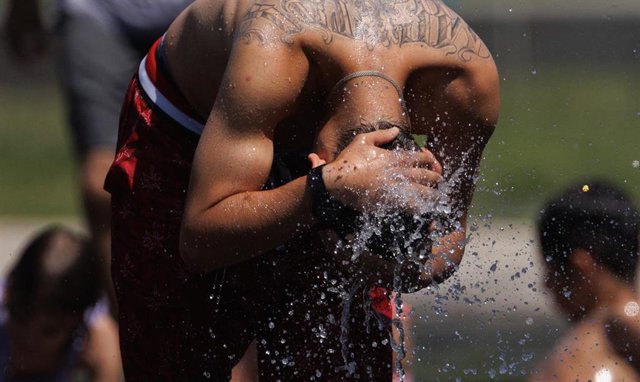 Un chico se refresca en Madrid Rio