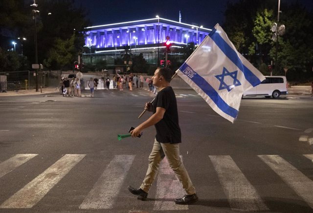 Manifestante contra la reforma judicial pasea ante el Parlamento de Israel 